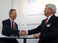 Volker Lowitsch, Geschäftsführer der Healthcare IT Solutions (links) unterzeichnet gemeinsam mit Erhard M. Brauer von der Health‐Comm GmbH auf der ConhIT einen 